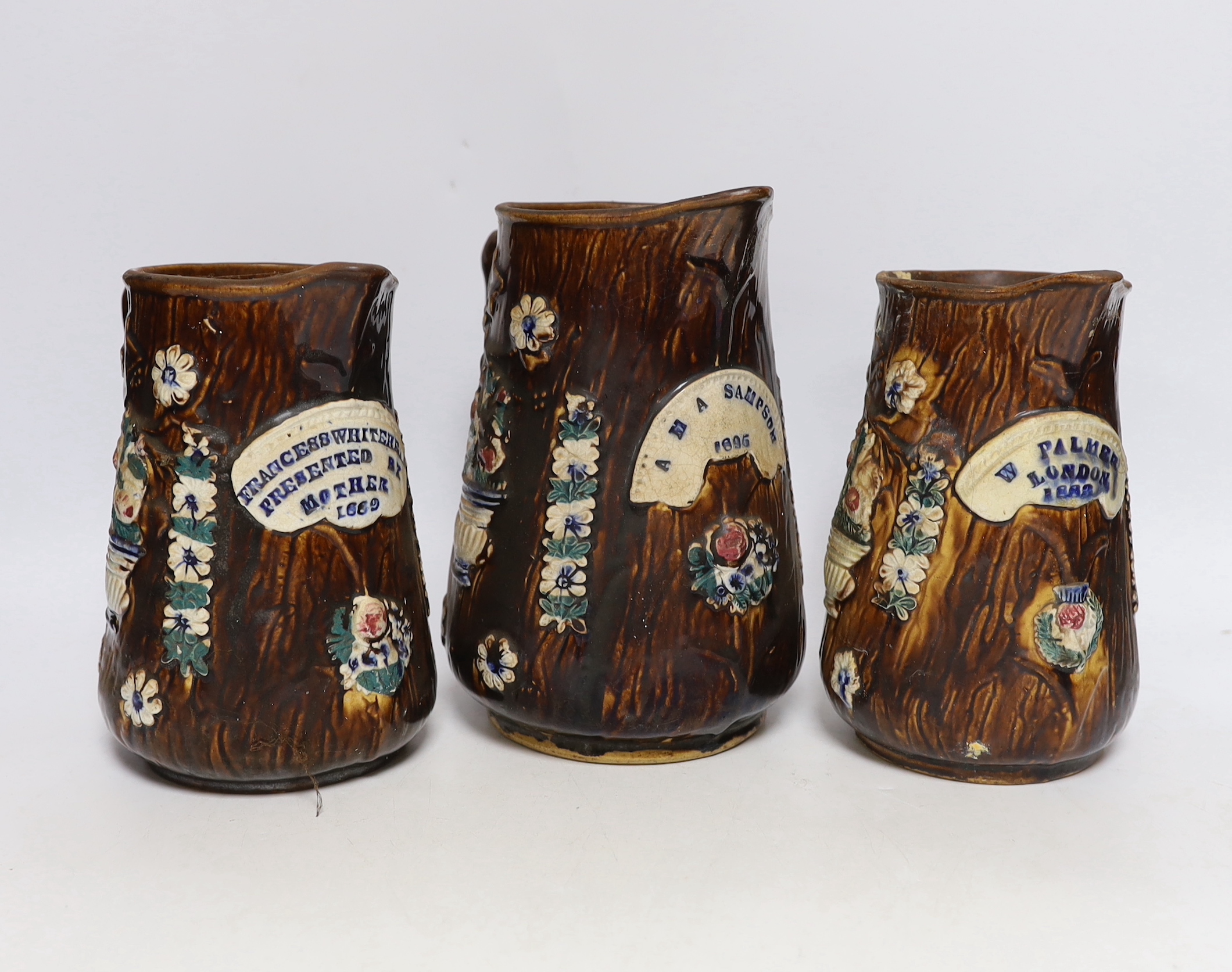 Three Measham barge ware glazed pottery jugs, decorated in relief, largest 22cm high